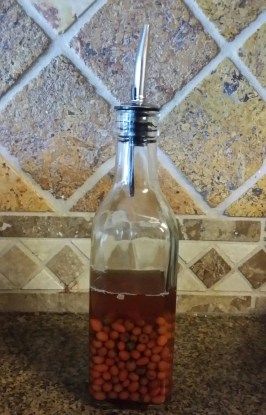 Picture shows peppers immersed in vinegar in a vinegar dispenser.