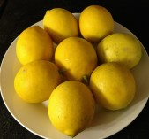 Whole Meyer lemons pictured on a plate.