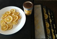 Dehydrated lemon slices on a plate, in a jar and on dehydration trays.